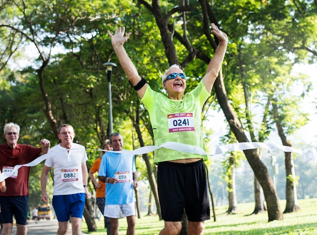 Feliz senior corriendo por la línea de meta