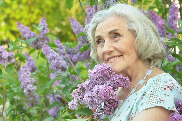 Feliz senior hermosa mujer con lilas