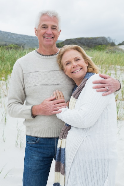 Feliz senior hombre abrazando a mujer en la playa