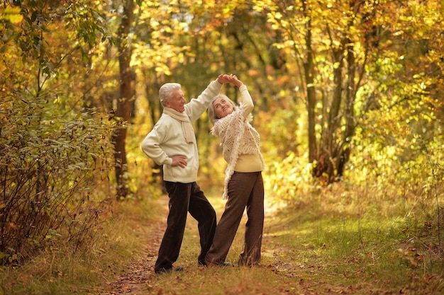 Feliz senior mujer y hombre en el parque saltando