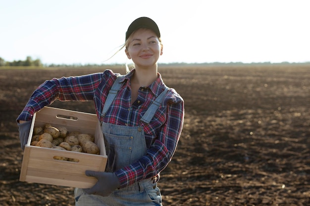 Feliz sonriente caucásica agricultora de patatas o jardinero Concepto de cosecha de producción de alimentos agrícolas