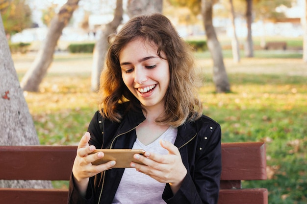 Feliz sonriente chica adolescente charlando con amigos por videollamada en el teléfono inteligente. Niña, saludo, amigos