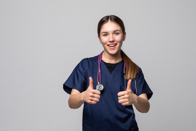 Feliz sonriente doctora con pulgares arriba gesto, aislado en blanco