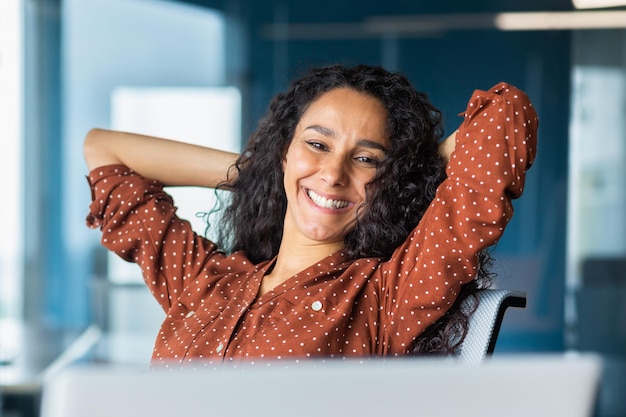 Feliz y sonriente exitosa mujer de negocios hispana terminó el trabajo satisfecha con el resultado del trabajo y