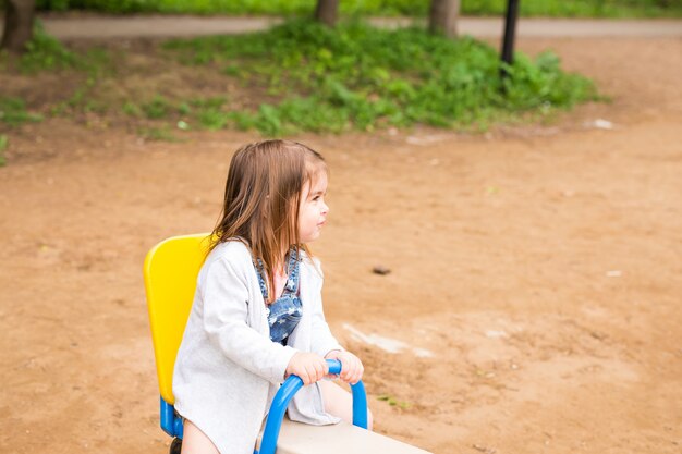 Feliz sonriente y hermosa niña divirtiéndose jugando en un parque en un día soleado