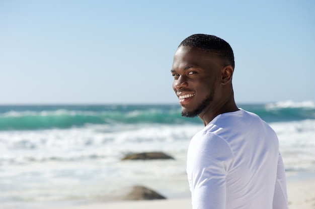 Feliz sonriente hombre afroamericano en la playa