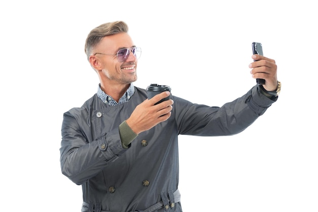 Feliz sonriente hombre de negocios empresario ceo en abrigo formal tomando selfie en el teléfono inteligente de negocios