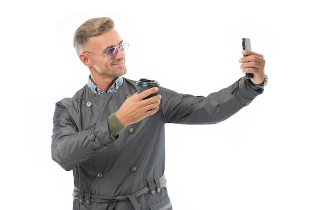 Feliz sonriente hombre de negocios jefe de negocios en abrigo formal tomando selfie en el teléfono inteligente de negocios