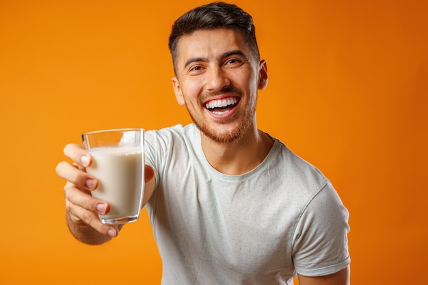 Feliz sonriente hombre de raza mixta con leche