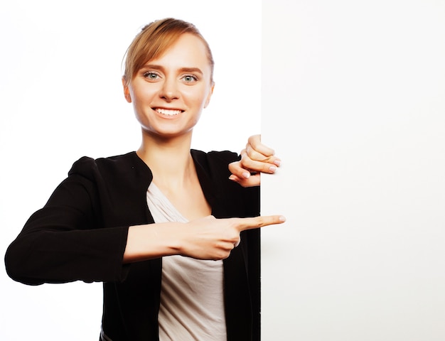 Feliz sonriente joven mujer de negocios mostrando letrero en blanco, sobre fondo blanco.