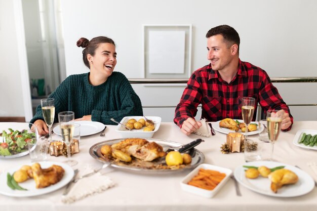 Feliz y sonriente joven pareja caucásica enamorada durante la reunión familiar de Navidad