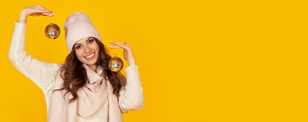 Feliz sonriente joven sosteniendo una bola de árbol de Navidad