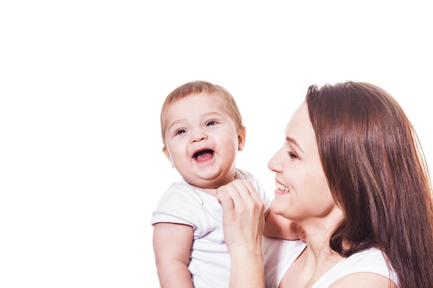 Feliz y sonriente madre y bebé en blanco