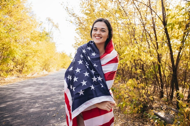 Foto feliz, sonriente, mujer joven, con, bandera estadounidense