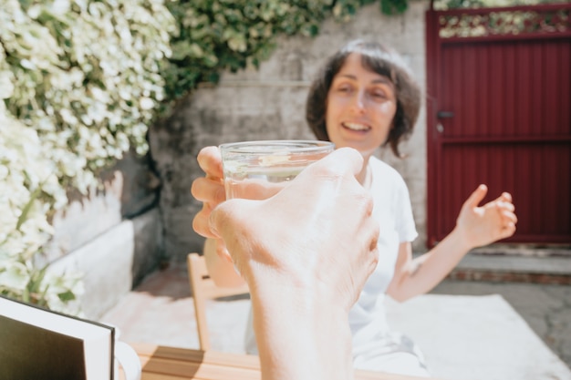 Feliz y sonriente mujer de mediana edad tomando una copa durante un día super soleado