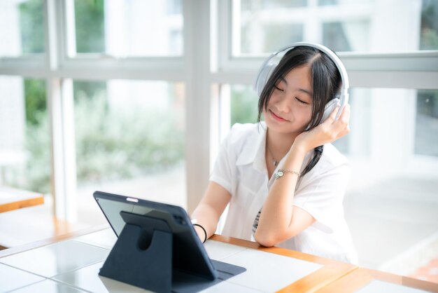 Feliz de sonrisas lindas asiática de atractiva joven chica linda pequeña con auriculares