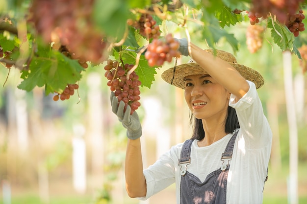 Feliz sorridente alegre vinha fêmea vestindo macacão e um chapéu de palha vestido de fazenda
