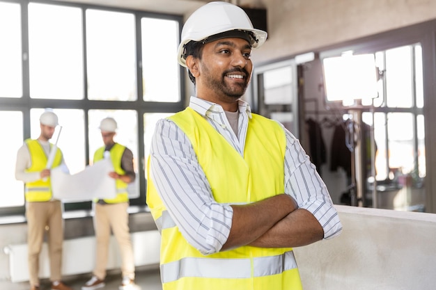 feliz sorridente arquiteto masculino em capacete no escritório