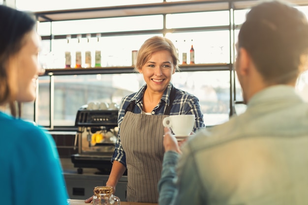 Feliz sorridente barista fazendo café e conversando com seus convidados no balcão do bar. Casal de boas-vindas experiente bartender. Pequena empresa, ocupação e conceito de serviço, espaço de cópia
