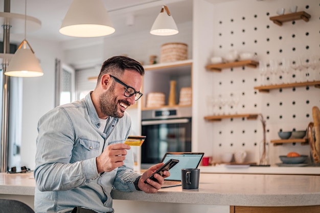 Feliz sorridente jovem adulto fazendo compras online