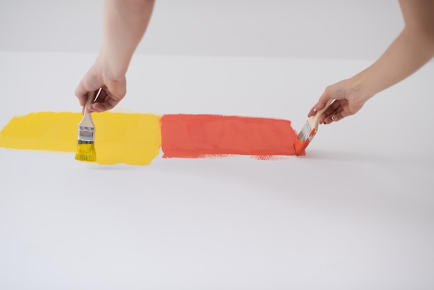 feliz sorridente jovem casal pintando a parede interior da casa nova