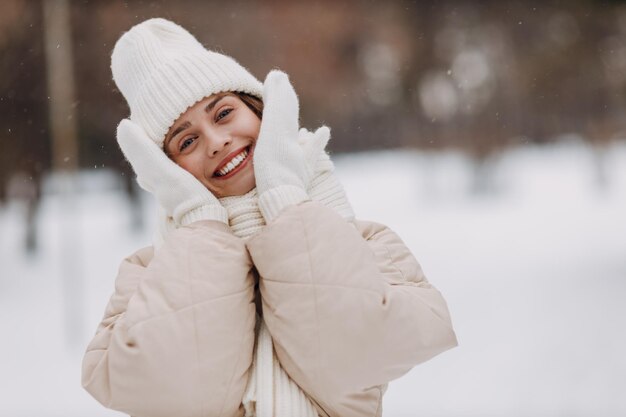 Feliz sorridente jovem retrato de mulher vestida casaco cachecol chapéu e luvas tocando sua pele suave do rosto em