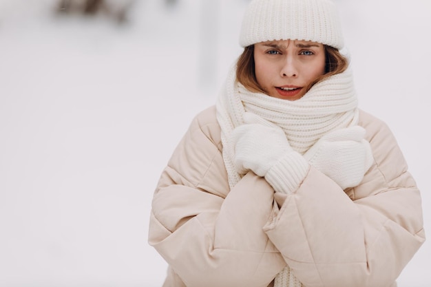 Feliz sorridente jovem retrato de mulher vestida casaco lenço chapéu e luvas gosta do tempo de inverno no parque de inverno frio e nevado