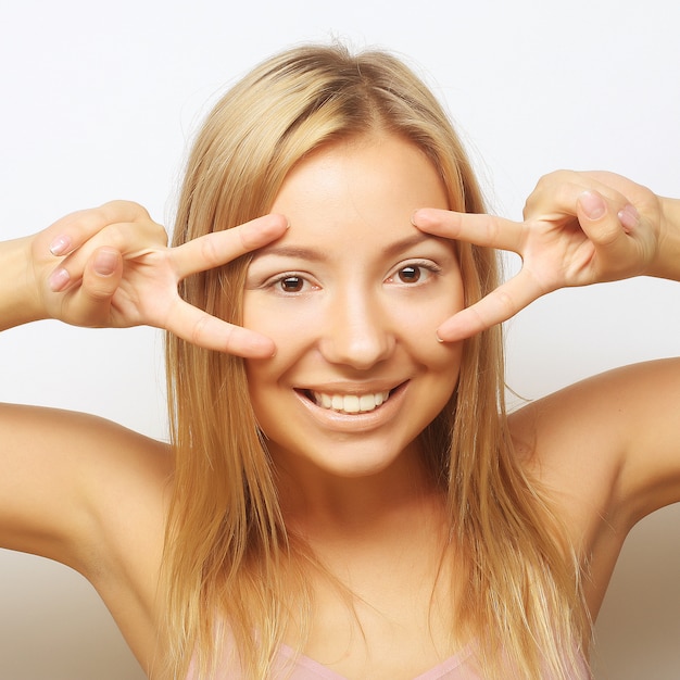 Feliz sorridente mulher jovem e bonita mostrando dois dedos ou victo