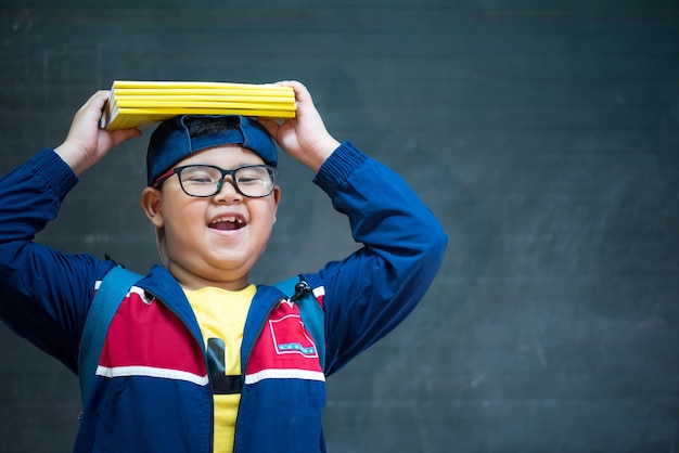 Feliz sorridente rapaz asiático em óculos está indo para a escola pela primeira vez