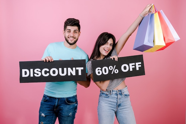 Feliz sorrindo bonito casal homem e mulher com desconto de 60% em sinal e sacolas coloridas