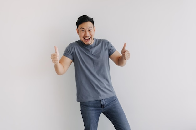 Feliz sorriso homem asiático mostrando dois polegares para cima para uma boa posição isolado em branco