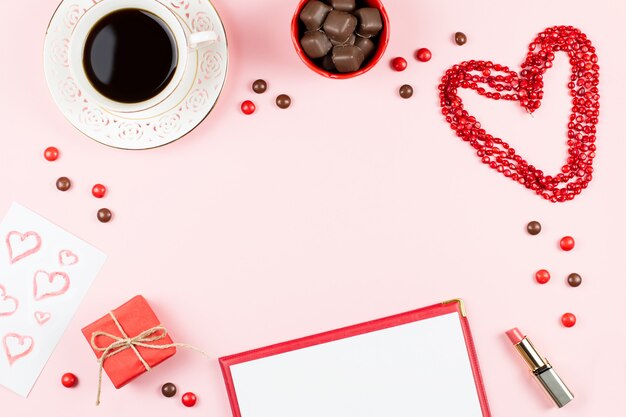 Feliz tarjeta de felicitación del día de San Valentín con café, dulces y caja de regalo en el fondo.