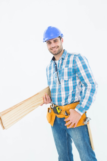 Feliz trabajador de la construcción con tablones de madera