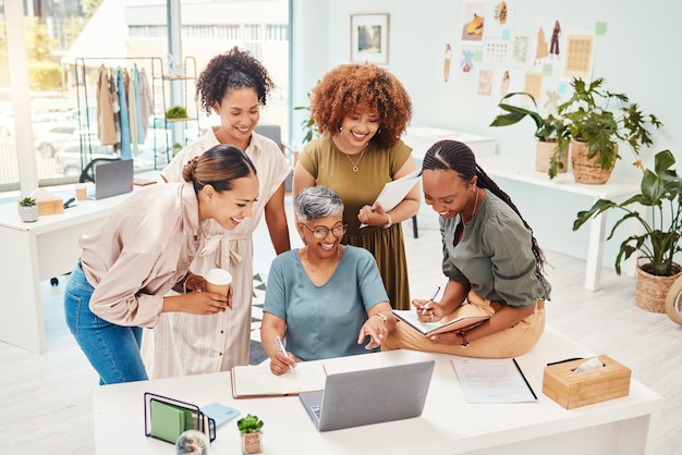 Feliz trabajo en equipo o mujeres con una computadora portátil para la planificación del diseño de moda o un borrador en línea para una línea de ropa. Mentor de sonrisas o diseñador maduro que habla o habla con personas para pedir consejo en pasantías.