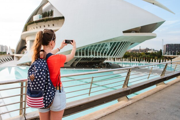 Feliz turista feminina é tirar uma foto na cidade de artes e Ciências em Valência