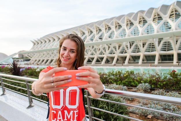 Feliz turista feminina está tomando uma selfie na cidade de artes e ciências em valência