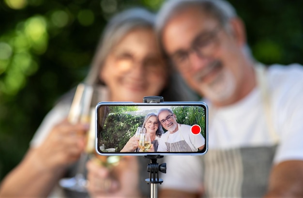 Feliz velho marido e esposa europeus fazem vídeo blog de selfie na tela do smartphone aplaudem com