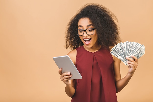 Feliz vencedor. retrato de uma mulher de negócios de sucesso com um penteado afro segurando muito dinheiro