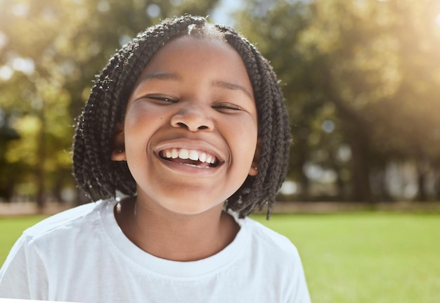 Feliz verão e retrato de criança negra no parque animado para diversão de férias no sol da África do Sul Felicidade de bem-estar e alegria de criança pronta para o sol ao ar livre na natureza com um sorriso alegre