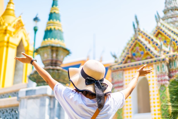 Feliz viagem asiática mulher no templo na Tailândia