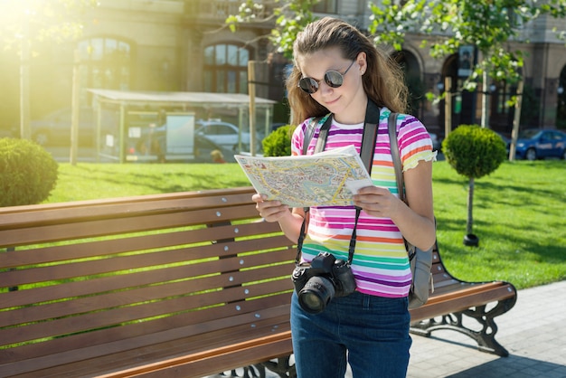 Feliz viaje turístico adolescente con cámara y mapa