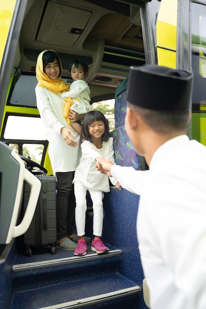 Feliz viaje de vacaciones musulmanas asiáticas en autobús junto con la familia con máscara que previene la propagación del virus