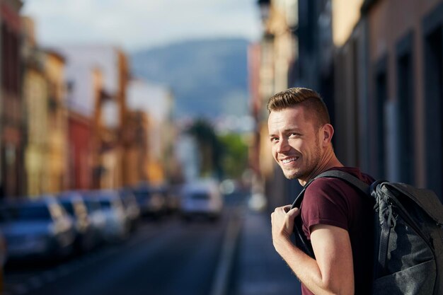 Foto feliz viajero en solitario mirando a la cámara hombre sonriente en la calle san cristóbal de la laguna