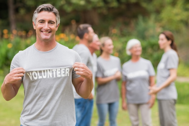 Feliz voluntario mostrando su camiseta a la cámara