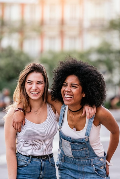 Felizes amigas de pé na cidade