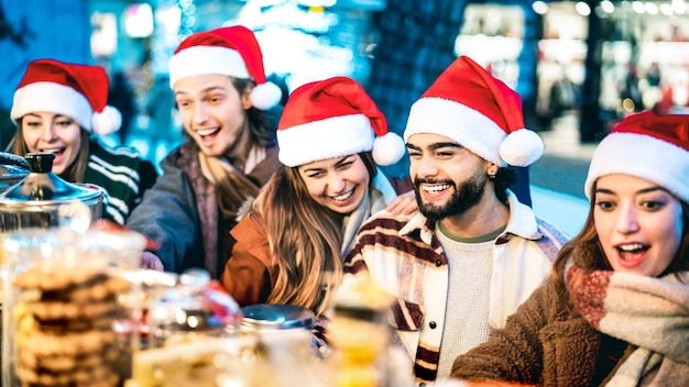 Felizes amigos da moda se divertindo fazendo compras no mercado de Natal