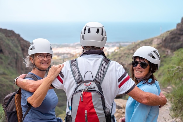 Felizes amigos idosos caminhantes com mochilas aproveitando o dia de trekking na montanha aproveitando a viagem