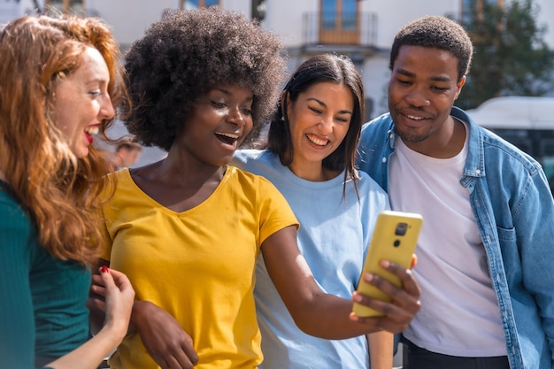 Felizes amigos multiétnicos se divertindo fazendo uma selfie em grupo na rua da cidade rindo juntos ao ar livre