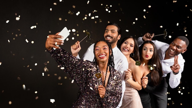 Foto felizes amigos multirraciais a celebrarem o ano novo juntos a tirar selfie.