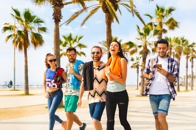 Felizes amigos na beira-mar a pé em barcelona